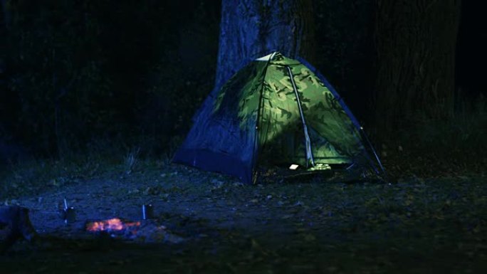 晚上，森林里燃烧的篝火旁的帐篷里的灯被关掉。