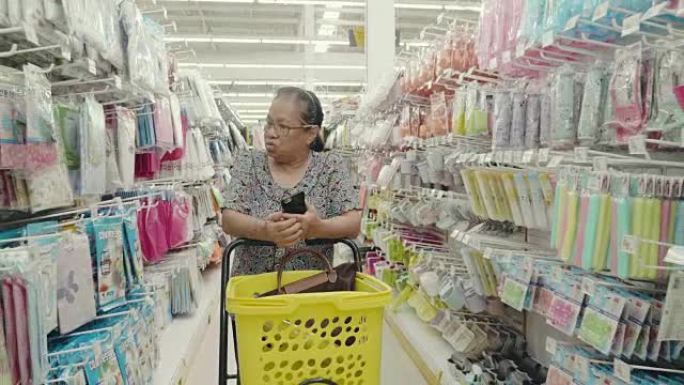 高级妇女在超市检查购物清单。