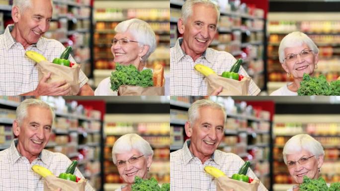 高级夫妇在杂货店里带着一袋蔬菜