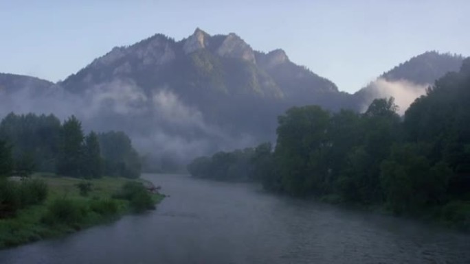 流动的河流被云杉森林环绕。背景中的山峰