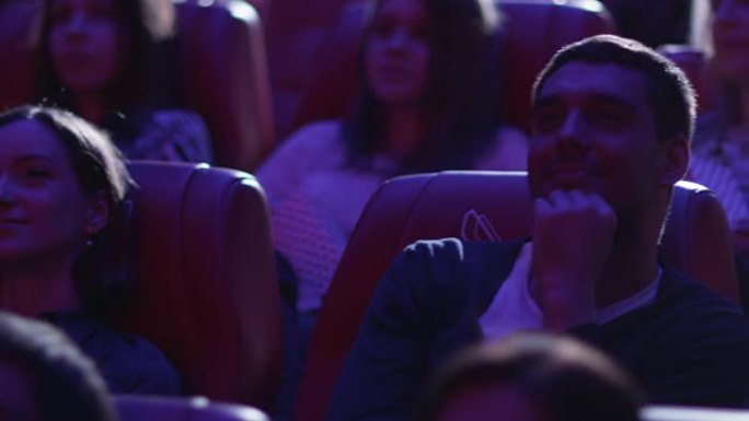 一群快乐的人正在电影院看电影放映。
