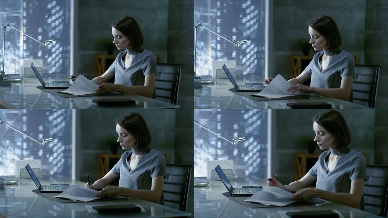 成功的年轻女子坐在办公桌前的私人办公室里，在笔记本电脑上工作，签署重要文件。她的办公室以极简主义风格