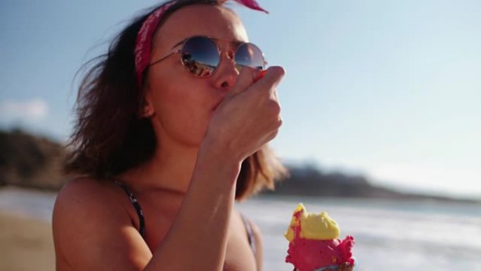 年轻女子在海滩上吃冰淇淋