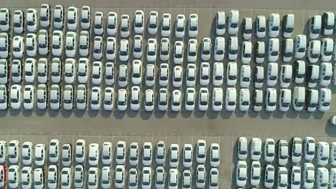 空中自上而下: 在工业港口停车场等待销售的全新汽车