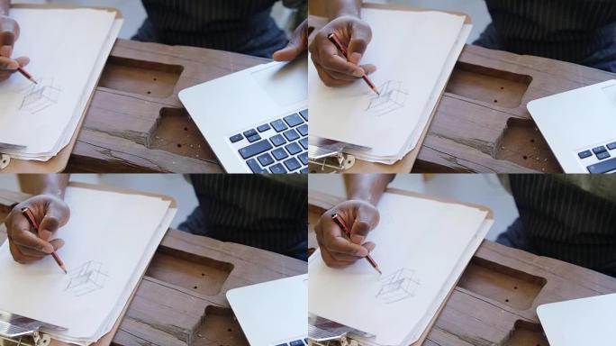 木匠在使用笔记本电脑4k时在纸上绘制草图