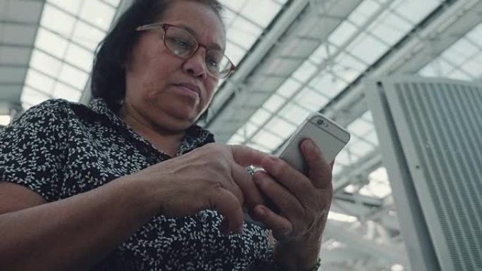 祖母在机场使用智能手机