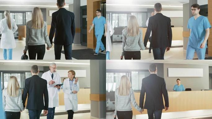 在医院拍摄后，这对年轻夫妇牵着手走向接待处。现代繁忙的医院设施。