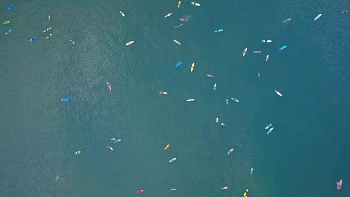 在巴厘岛拥挤的阵容中，彩色冲浪板上的空中冲浪者在拥挤的阵容中等待