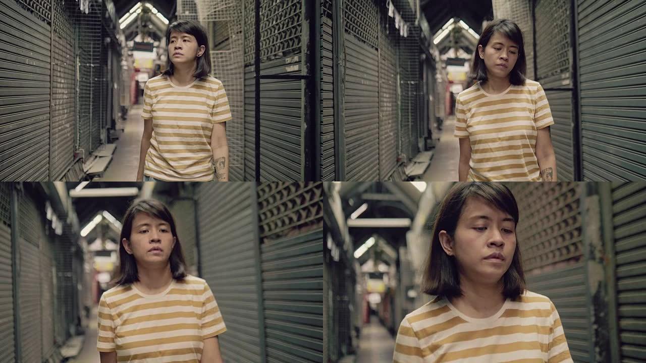 悲伤的年轻亚洲女子独自在封闭的商店里行走