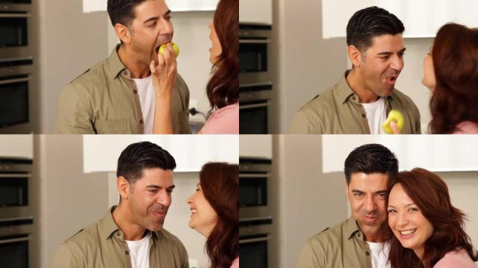 女人开玩笑地喂男友一个青苹果