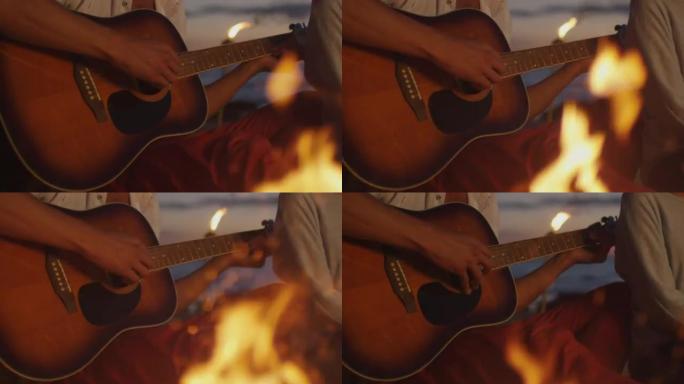晚上，一群人在篝火旁闲逛，一个人在弹吉他。