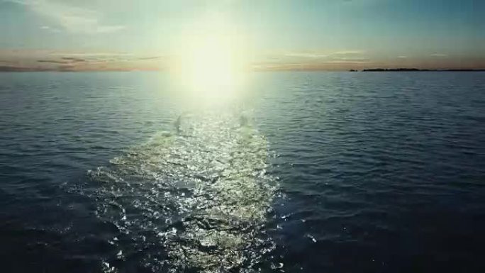 空中无人机拍摄的两只天鹅开始飞向海上的日落。