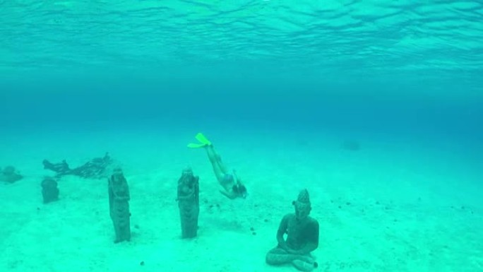 水下: 年轻的女潜水员在水下游泳和浮潜，在梦幻般的水晶般清澈的海洋泻湖中探索沉没的雕像保护区