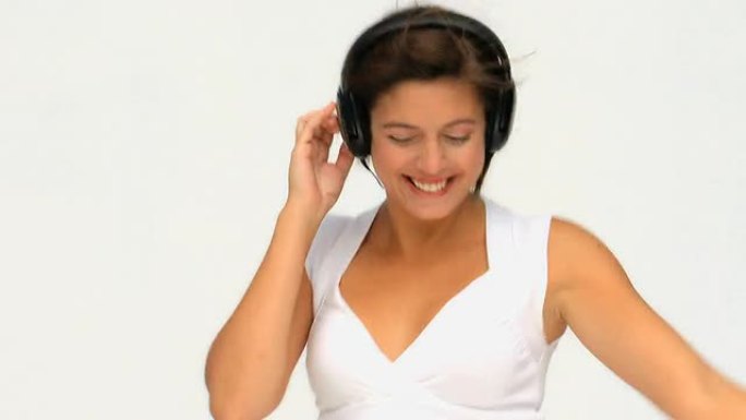 可爱的黑发女人戴着耳机听音乐