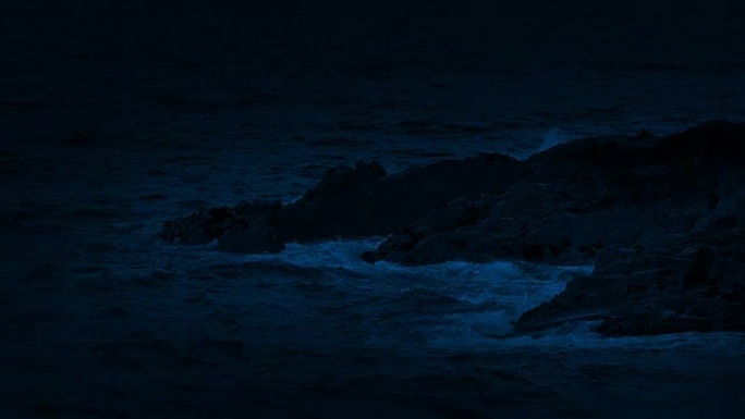 海浪在夜间在岩石上破裂
