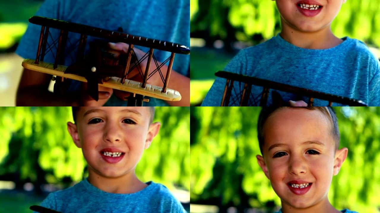 微笑的男孩在公园里玩玩具飞机