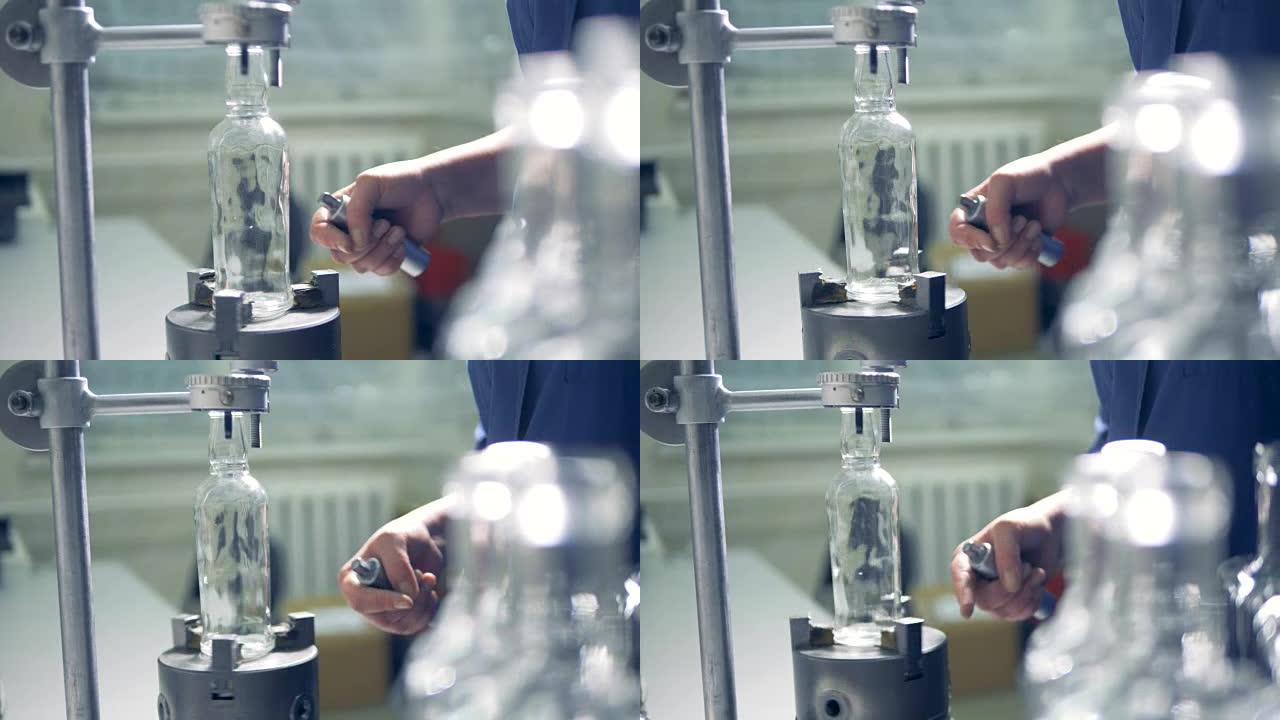工厂工人检查瓶子，在一个特殊的仪器上旋转它。4 k。