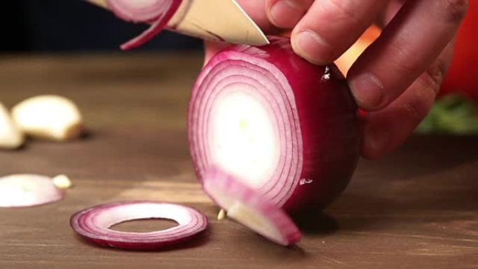 厨师用刀将红洋葱切成薄片