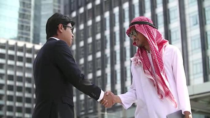 阿拉伯和中国商人握手。现代城市背景。国际业务和海外合作。