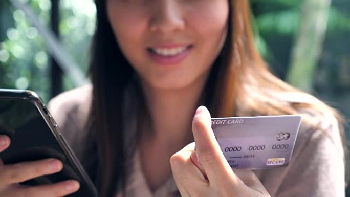 女人在手机上插入信用卡号，有智能手机的网上银行