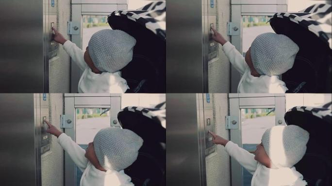 亚洲男婴按下按钮打开电梯门。