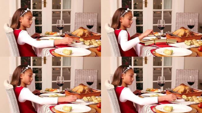 小女孩在圣诞晚餐上吃土豆