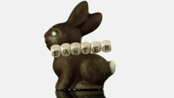 拼写复活节落在巧克力兔子面前的字母
