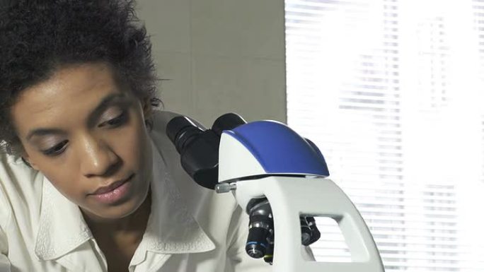 使用显微镜的女科学家