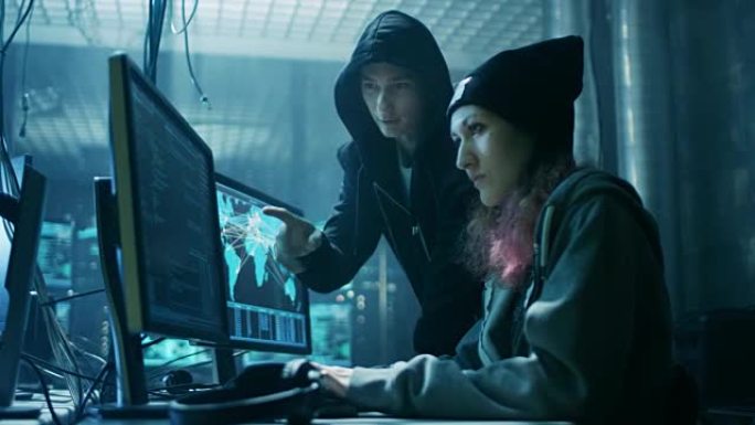 国际通缉的男孩和女孩黑客团队组织对公司服务器的高级病毒攻击。地方是黑暗的，有多个显示器。