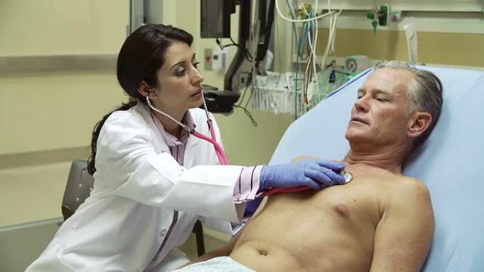 医生在医院病床上检查成熟的男性患者