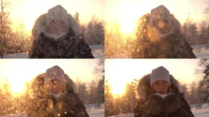 慢动作: 年轻女子在神奇的冬天在夕阳下吹雪花