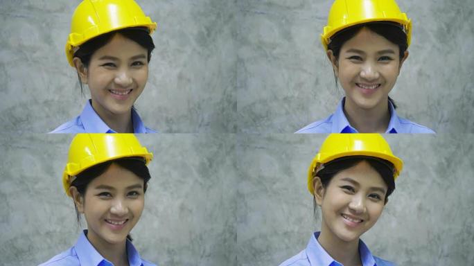 戴着头盔的亚洲女工程师的肖像对着镜头微笑。