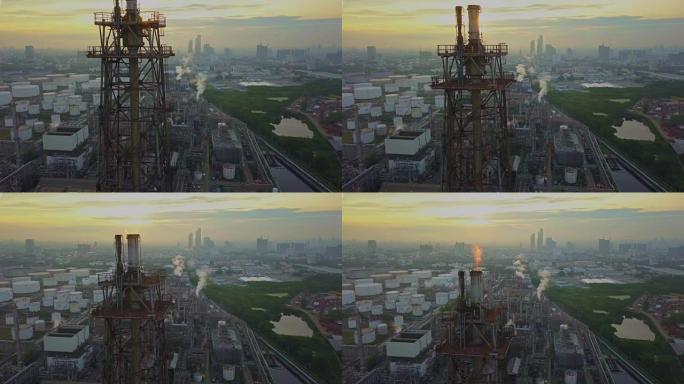 城市日出时燃烧火炬的化工或炼油厂的鸟瞰图