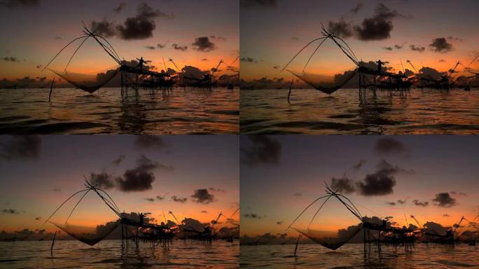 剪影早晨日出时渔夫的工具。