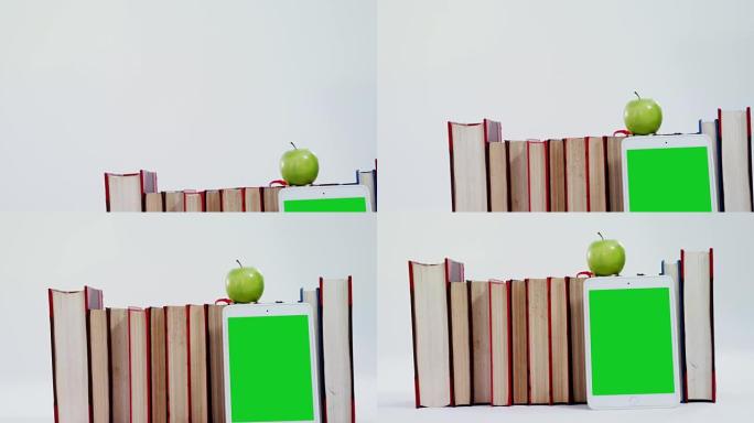 苹果，数字平板电脑和白色背景上的书籍