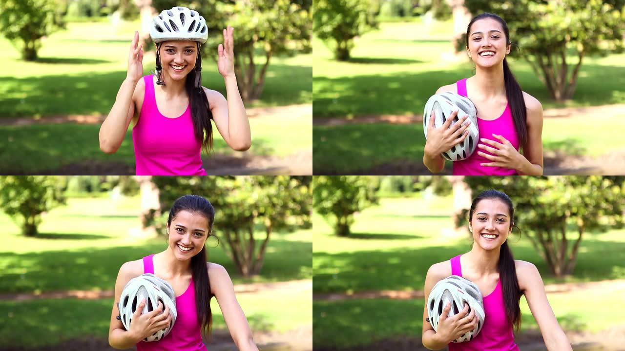 健康的女孩脱下自行车头盔对着镜头微笑