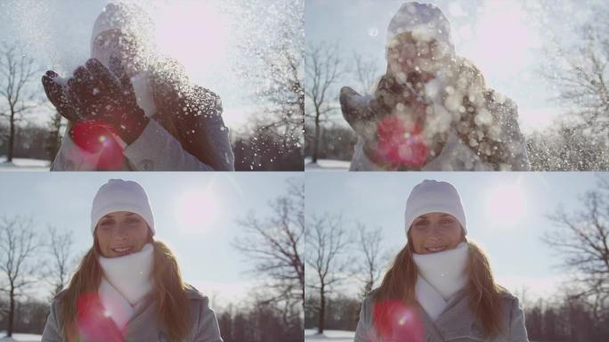 慢动作: 年轻女子在阳光下吹雪花