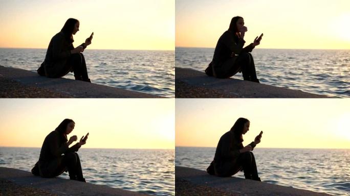 女人在海边日落时检查短信