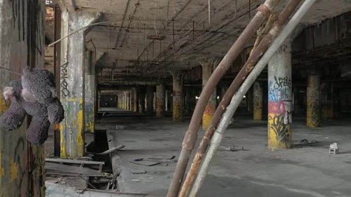 特写: 泰迪熊挂在废弃的腐烂工业大厅的钩子上