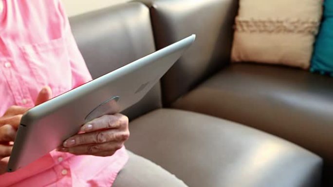 玩平板电脑的退休妇女的特写镜头