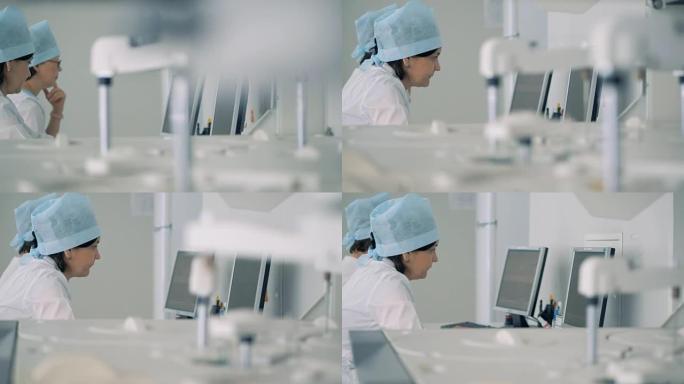 两名科学家在计算机前工作，同时一台医疗机器在进行测试。