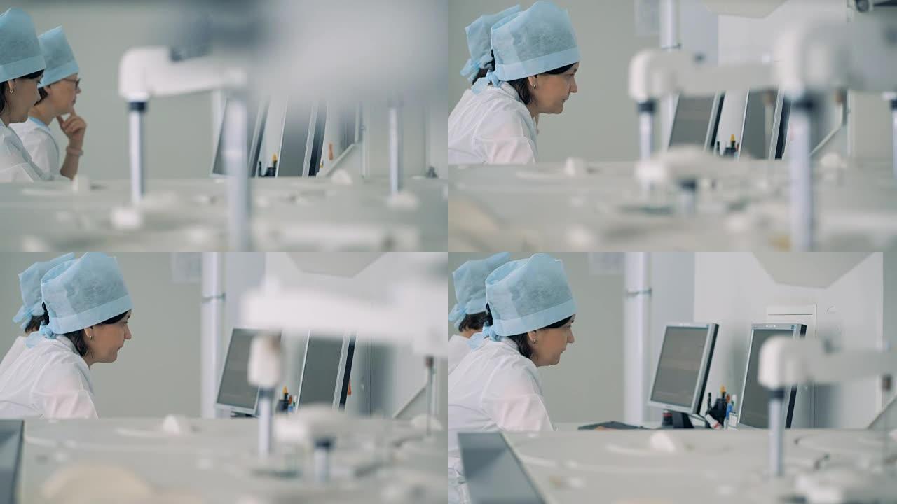 两名科学家在计算机前工作，同时一台医疗机器在进行测试。