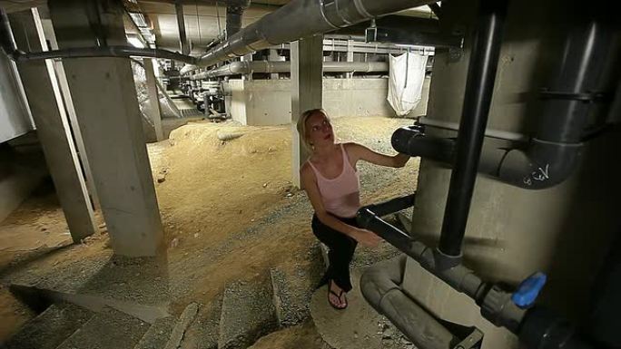 一名女工程师正在检查一家大型技术工厂的地下