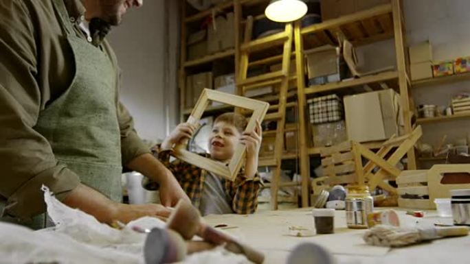 儿子和父亲打磨木制相框