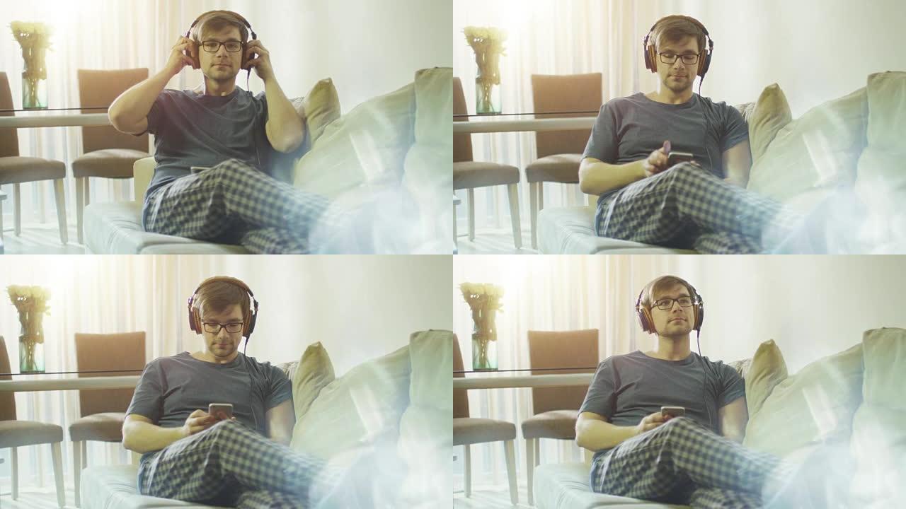 男人早上在沙发上听音乐。在4k (UHD) 的红色电影相机上拍摄。