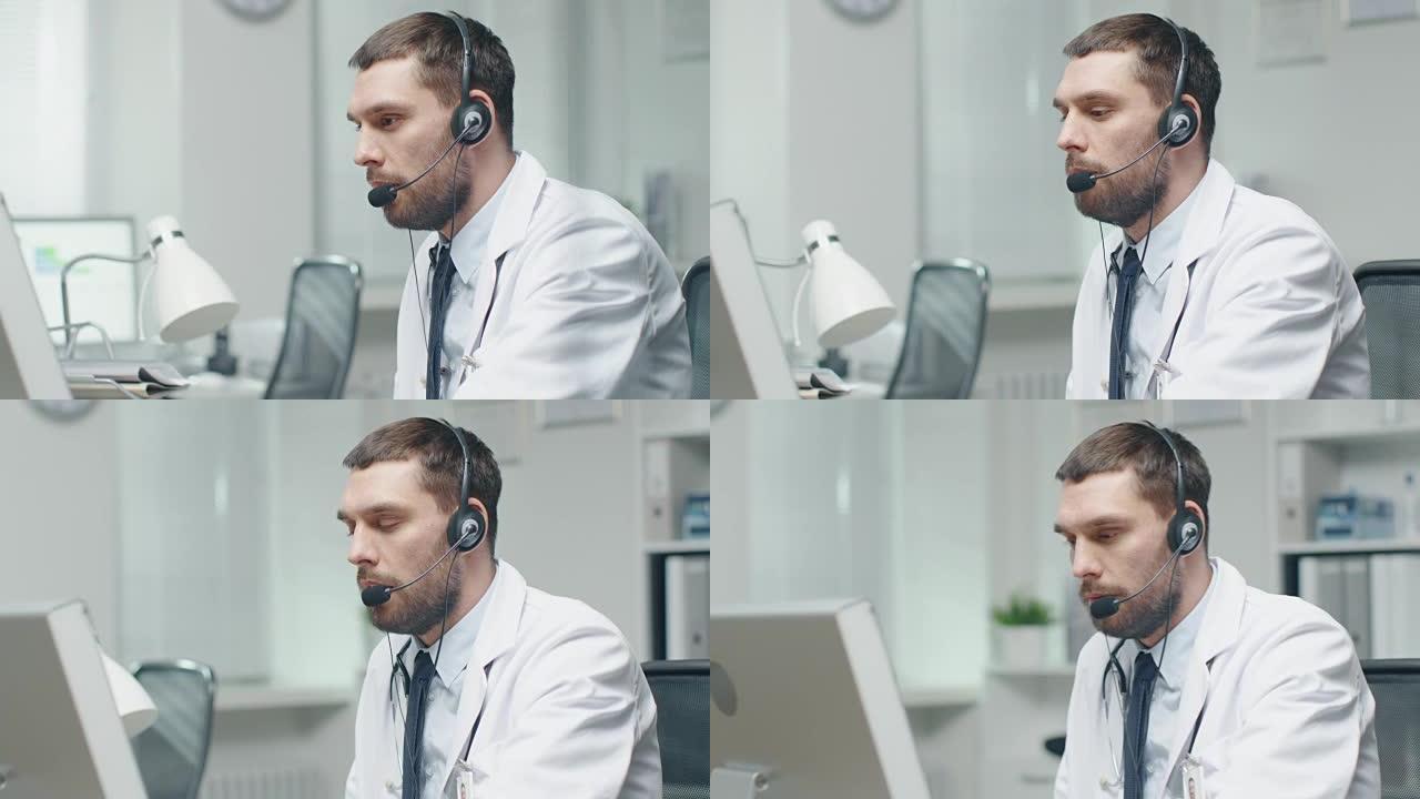 男医生在网上咨询病人。他坐在个人电脑前，戴着麦克风。