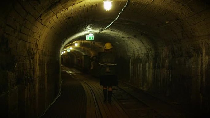 戴着安全帽的工人正在采矿隧道中行走