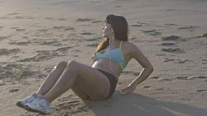 运动的女人在海滩上锻炼