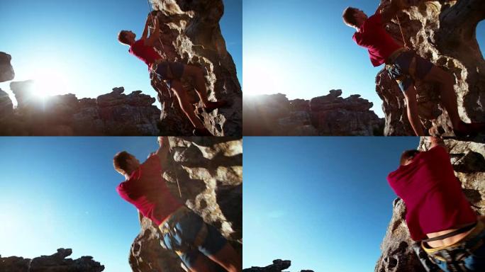 专注的攀岩者从巨石上吊时抓着抓地力