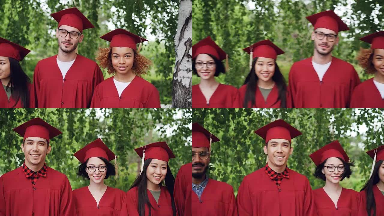 穿着红色毕业礼服和灰泥板站在户外，微笑着看着相机的跨国学生团体的肖像。